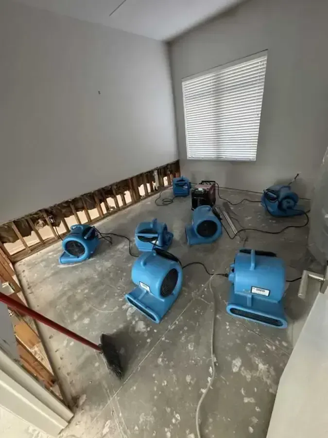 Emptied room with flood-cut drywall and air movers running