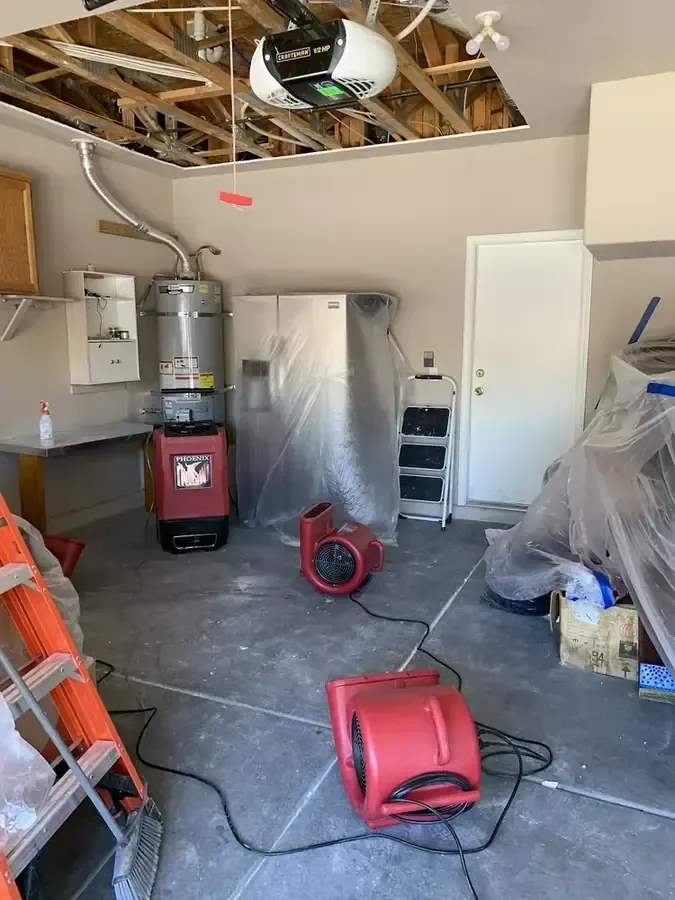 Garage dried with air movers and a dehumidifier after a water heater leak