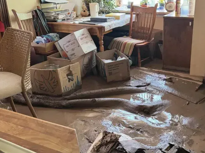 Mud and flood water spread over a room floor, waiting for cleanup